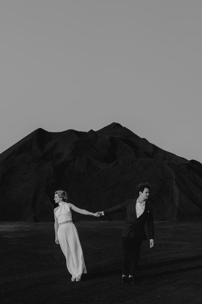 black and white photo of bride and groom in mountain landscape