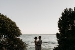 bride and groom hugging during ocean sunset