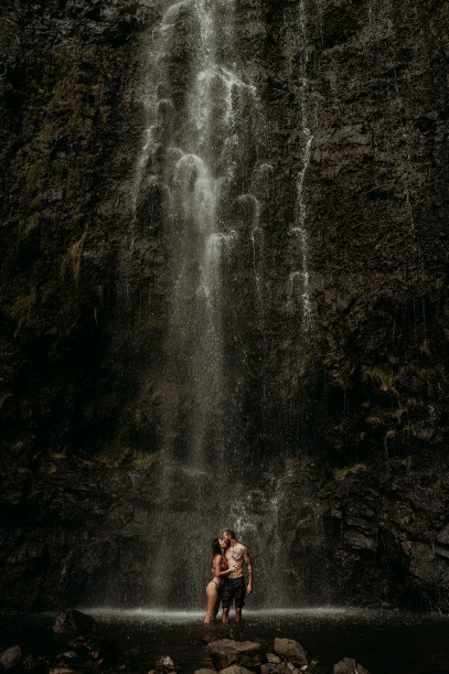 couple kissing underneath waterfall