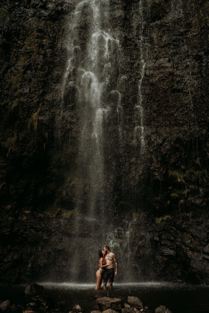 couple kissing underneath waterfall