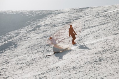 bride and groom skiing down a snowy slope