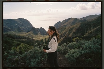 kaat and her camera in front of mountain and ocean landscape