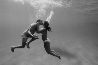 black and white photo of newly wed couple kissing underwater