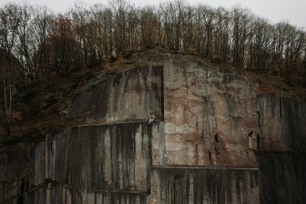 two men sitting on edge of old quarry