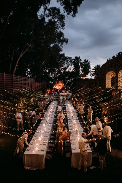 weddings guests looking for their seat along two long tables